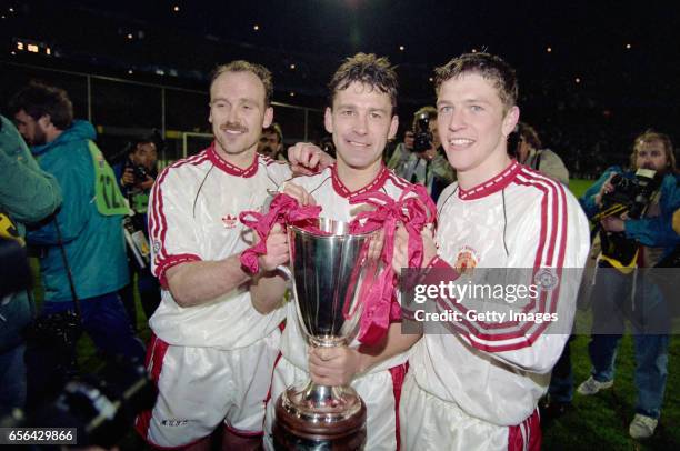 Manchester United captain Bryan Robson celebrates with the trophy with team mates Mike Phelan and Lee Sharpe after the 1991 UEFA European Cup Winners...