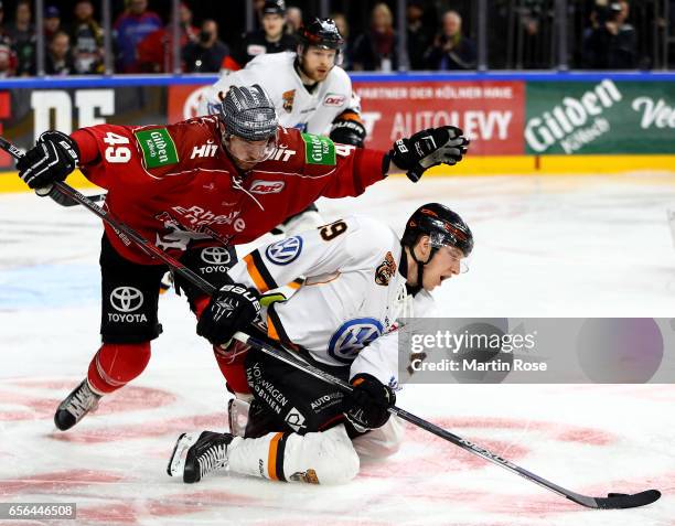 Alexandre Bolduc of Koeln and Mark Voakes of Wolfsburg battle for the puck during the DEL Playoffs quarter finals Game 7 between Koelner Haie and...