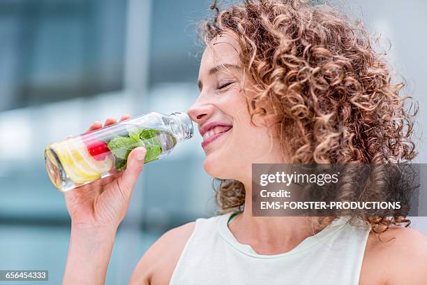 healthy woman drinks natural lemonade - glas bottle imagens e fotografias de stock