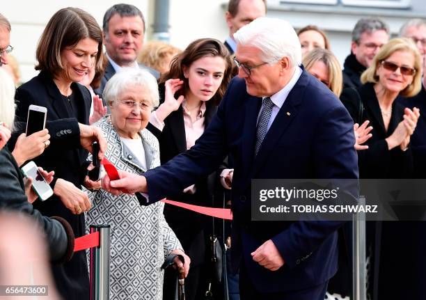 The new German President Frank-Walter Steinmeier opens the security fence his mother Ursula Steinmeier during an official ceremony during which he...