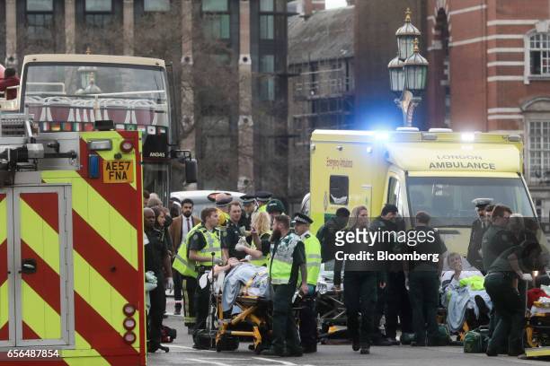 Members of the emergency services tend to individuals injured during an incident on Westminster Bridge near the Houses of Parliament in central...