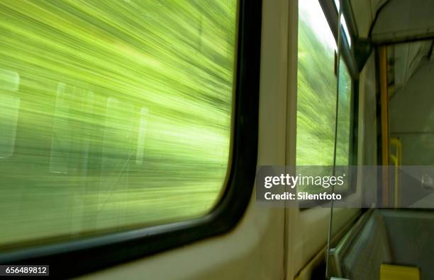 looking out of train window at foliage whizzing passed - vorbeigehen stock-fotos und bilder