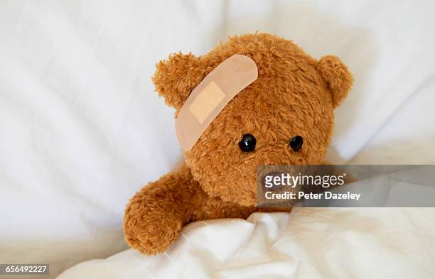 injured teddy bear with plaster - ours en peluche photos et images de collection