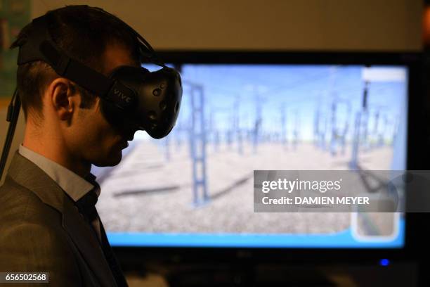 Visitor uses gloves and a Virtual Reality headset during the "Laval Virtual" virtual reality, augmented reality and 3D techonology show on March 22...
