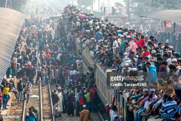 zug voller passagiere betreten station am nebligen tag - bangladesh stock-fotos und bilder