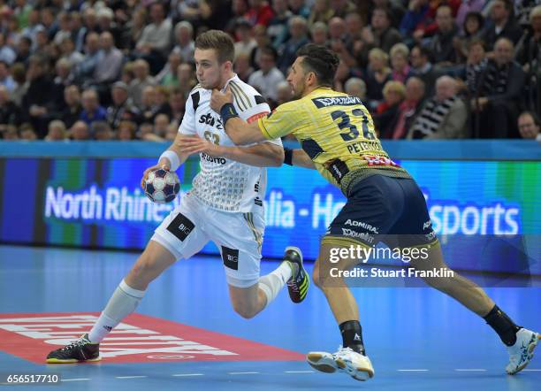 Nikola Bilyk of Kiel is challenged by Alexander Petersson of Rhein Neckar during the first leg round of 16 EHF Champions League match between THW...