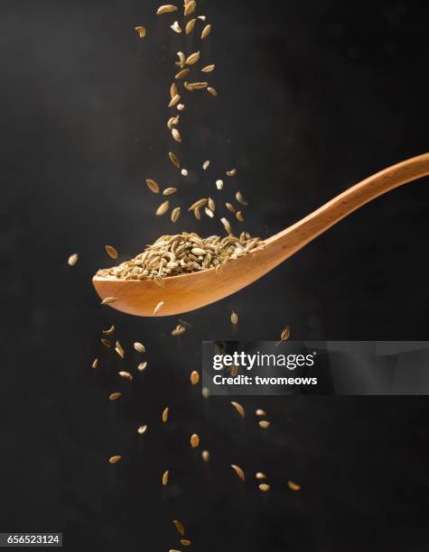 close up view of cumin in wooden spoon. - cumin stock pictures, royalty-free photos & images