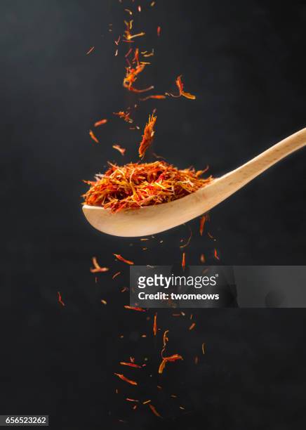 close up view of saffron in wooden spoon. - saffron stock pictures, royalty-free photos & images