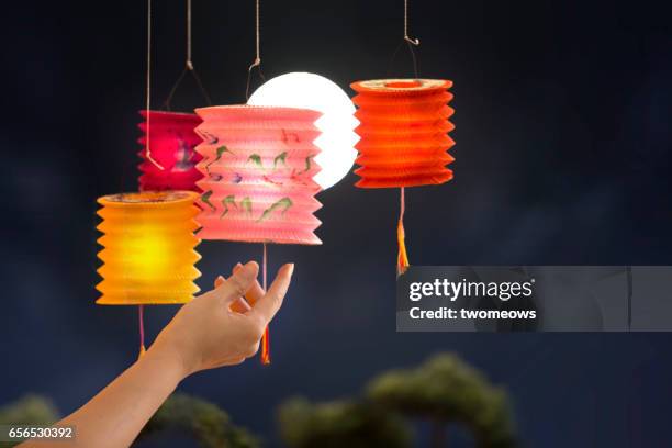 female's hand holding colourful lanterns on full moon sky background. - 中秋節 ストックフォトと画像