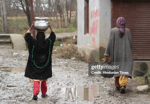 Kashmiri woman carries a water pot over her head after collecting water from a river on March 22, 2017 in Pattan, North of Srinagar, India. World...