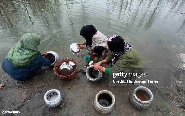 Women washing utensils on the bank of a river on March 22, 2017 in Pattan, North of Srinagar, India. World Water Day is observed on 22 March every...