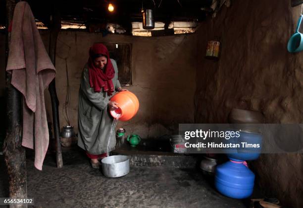 Kashmiri woman fills a pot with water after collecting it from a river on March 22, 2017 in Pattan, North of Srinagar, India. World Water Day is...