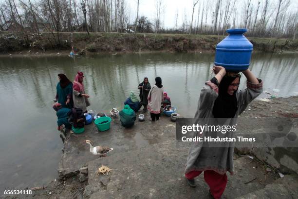 Kashmiri woman carries a water pot over her head after collecting water from a river on March 22, 2017 in Pattan, North of Srinagar, India. World...