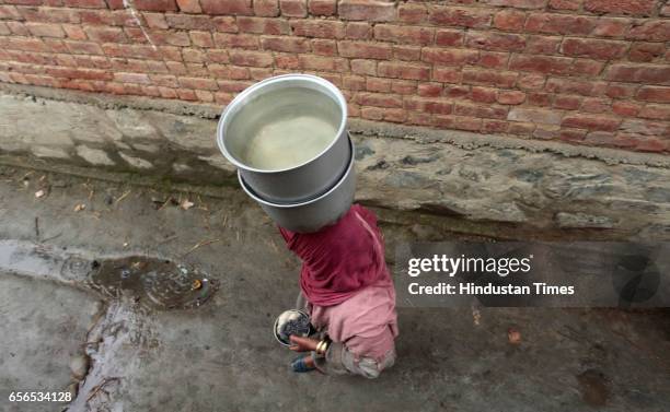 Kashmiri woman carries a water pot over her head after collecting water from a river on March 22, 2017 in Pattan, North of Srinagar, India. World...