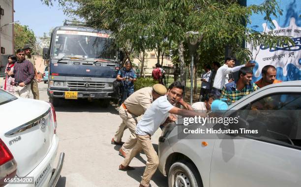 People pushing away an oddly parked car blocked the way of police van with Ajmer blast convicts Devendra Gupta and Bhavesh Patel on March 22, 2017 in...