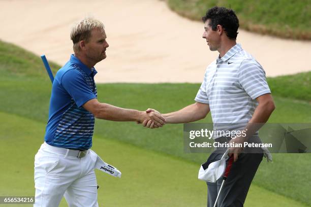 Soren Kjeldsen of Denmark shakes hands with Rory McIlroy of Northern Ireland after winning their match during round one of the World Golf...