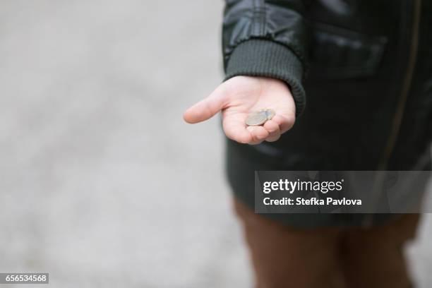 boy holding coins in his hand - childhood poverty stock pictures, royalty-free photos & images