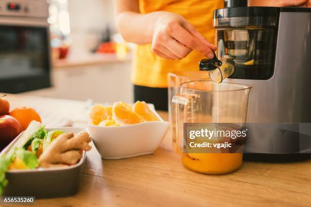 woman making cold-pressed juice - juicer stock pictures, royalty-free photos & images