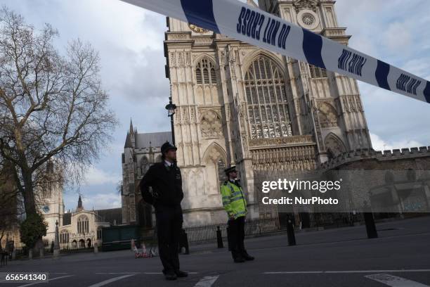 Police officers stand guard outside the Palace of westminster and an Westminster bridge in central London on March 22, 2017 during an emergency...