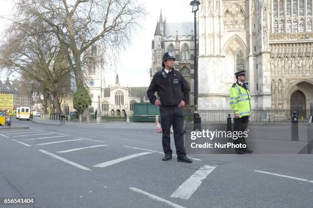 Police officers stand guard outside the Palace of westminster and an Westminster bridge in central London on March 22, 2017 during an emergency...