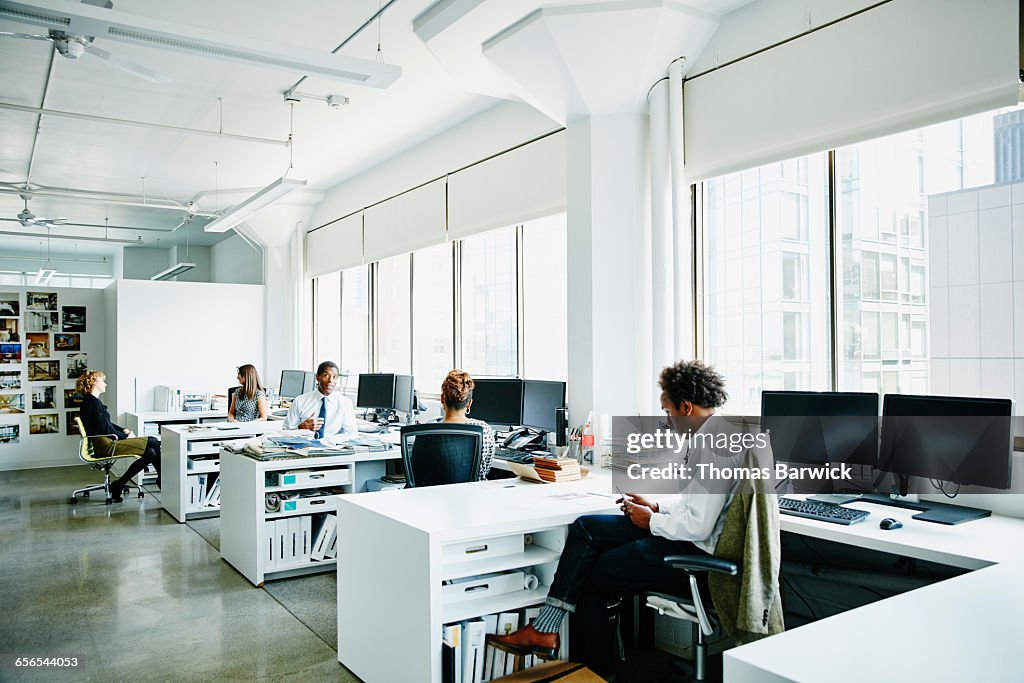 Businesspeople working at workstations in office
