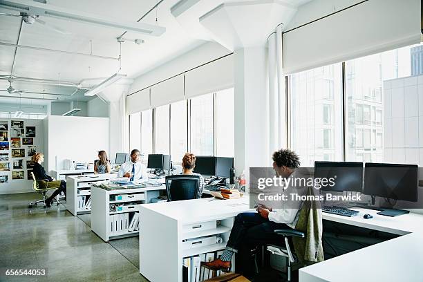 businesspeople working at workstations in office - workstation imagens e fotografias de stock