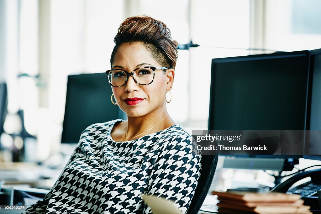 Smiling businesswoman seated at office workstation