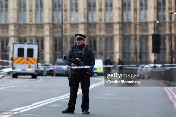 An armed British police officer stands at a cordon near Westminster Bridge and the Houses of Parliament in central London, U.K., on Wednesday, March...