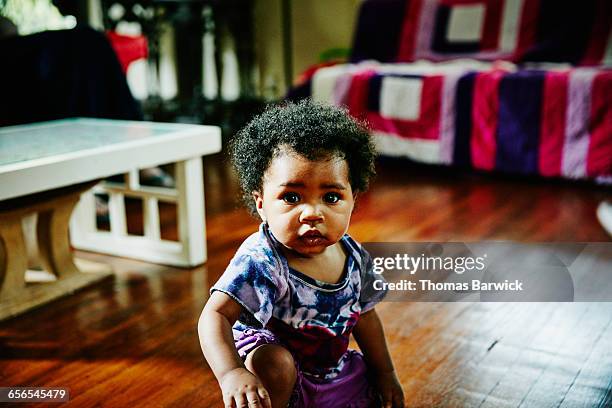 portrait of infant girl playing in living room - african american baby girls stock pictures, royalty-free photos & images