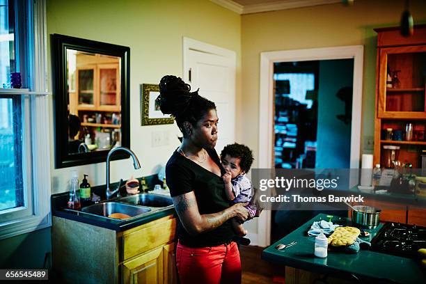 Mother holding infant in kitchen after dinner