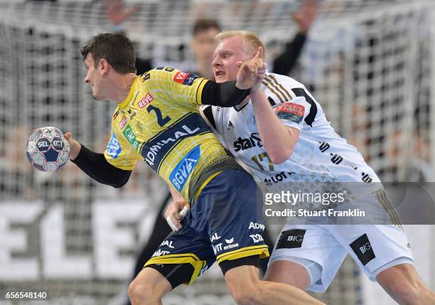 Patrick Wiencek of Kiel is challenged by Andy Schmid of Rhein Neckar during the first leg round of 16 EHF Champions League match between THW Kiel and...