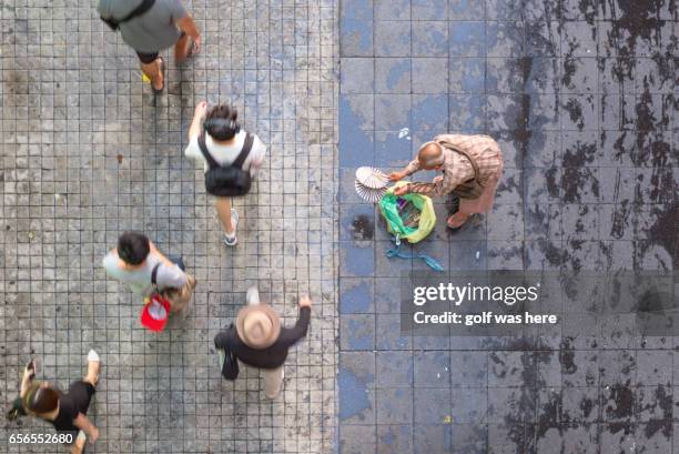 a man walks a past a begger - arm around stockfoto's en -beelden