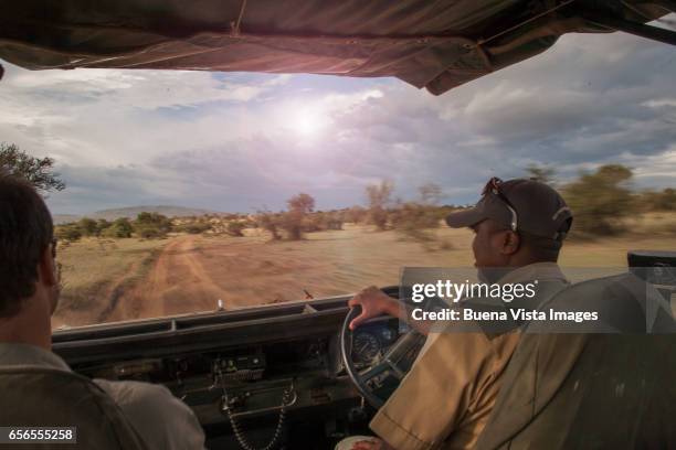 four wheels drive on a dirt road in the savannah - east africa photos et images de collection