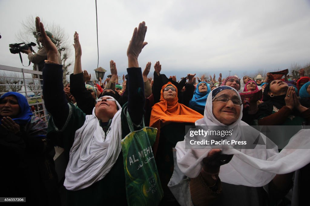 Women raise hands towards the holy relic being displayed by...