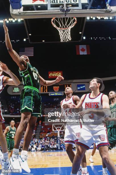 Anthony Avent of the Milwaukee Bucks rebounds against the New Jersey Nets during a game played circa 1993 at the Brendan Byrne Arena in East...