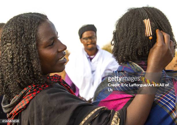 Borana tribe woman adjusting the hair decoration of a friend that indicates how many children she had, Oromia, Yabelo, Ethiopia on March 3, 2017 in...