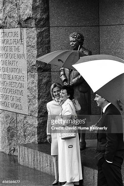 First Lady Hillary Clinton holds an umbrella for Cherie Blair, the spouse of British Prime Minister Tony Blair at the FDR memorial on February 6,...
