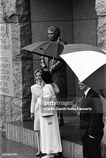 First Lady Hillary Clinton holds an umbrella for Cherie Blair, the spouse of British Prime Minister Tony Blair at the FDR memorial on February 6,...