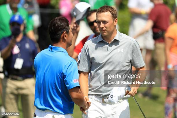 Hideto Tanihara of Japan shakes hands with Jordan Spieth after defeating him on the 16th hole of their match during round one of the World Golf...