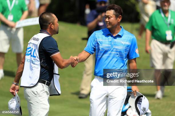 Hideto Tanihara of Japan celebrates with his caddie after defeating Jordan Spieth , on the 16th hole of their match during round one of the World...