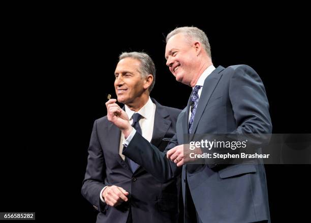 Howard Schultz and President and Chief Operating Officer Kevin Johnson pose for a photo with a key to the original Starbucks store during Starbucks...