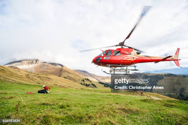 mountain rescue heli startet vom berghang - rettung stock-fotos und bilder