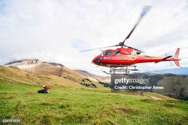 mountain rescue helicopter takes off from mountain side - helicopter rescue stock pictures, royalty-free photos & images