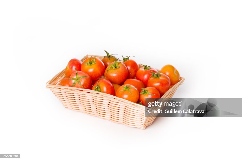 Basket with ripe tomatoes to sprinkle bread