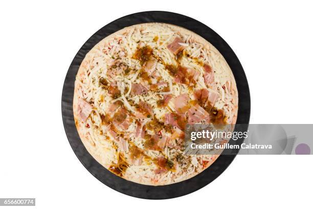 pizza ready to put in the oven on black plate and white background - tentempié 個照片及圖片檔