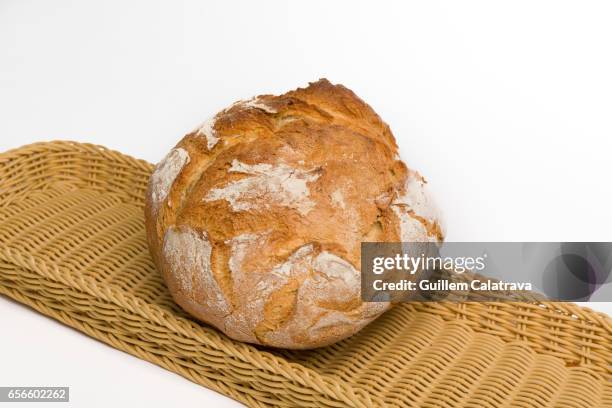 unpeeled round baked bread with flour on top over basket on white background - horno pan stock pictures, royalty-free photos & images