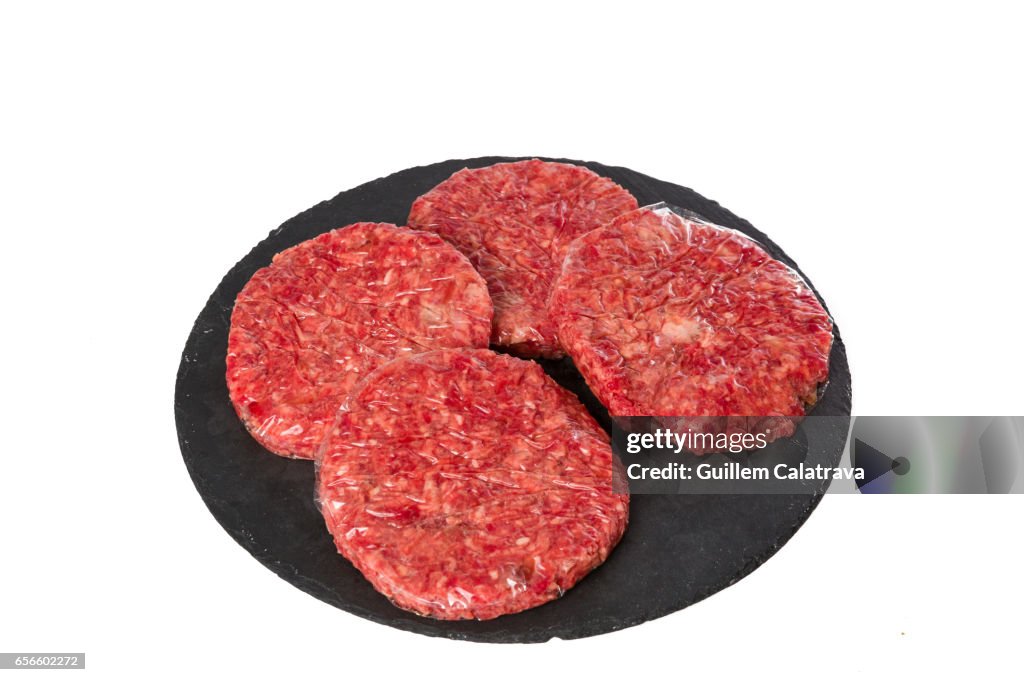 4 burgers on a black plate