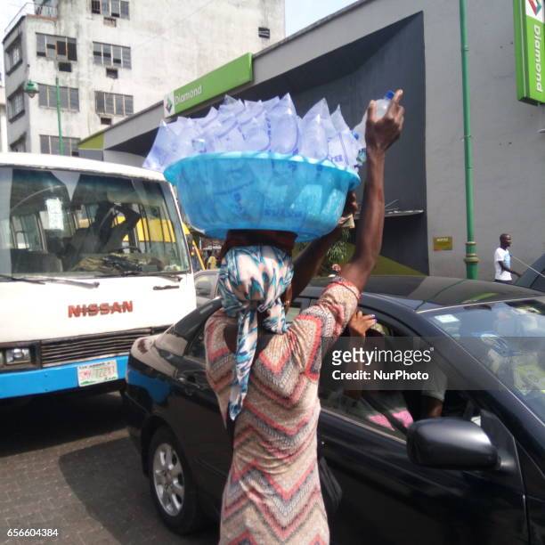 Woman sells water in traffic at Broad Street in Lagos, Nigeria on Wednesday, March 22 2017. Cost of getting quality water in Lagos is rising daily....