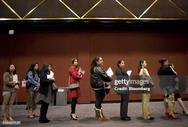 People stand in line to receive their papers during a naturalization ceremony in San Diego, California, U.S., on Wednesday, March 22, 2017. Hawaii's...