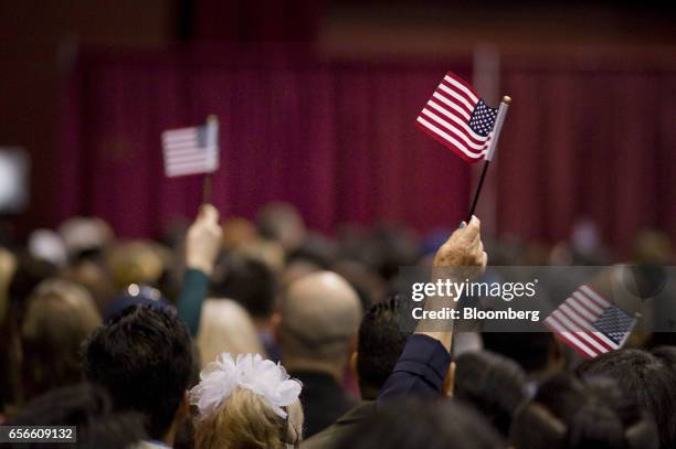 People wave miniature American flags during a naturalization ceremony in San Diego, California, U.S., on Wednesday, March 22, 2017. Hawaii's attorney...